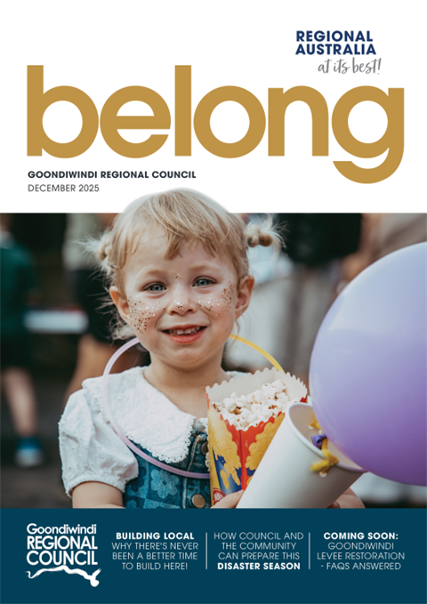 woman in colourful dress standing with hand on hip in front of a stage with easel and flowers at international day of womens event